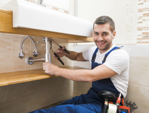 Ekspert hydraulik z firmy remontowej Multitechnik podczas prac remontowych łazienki. 